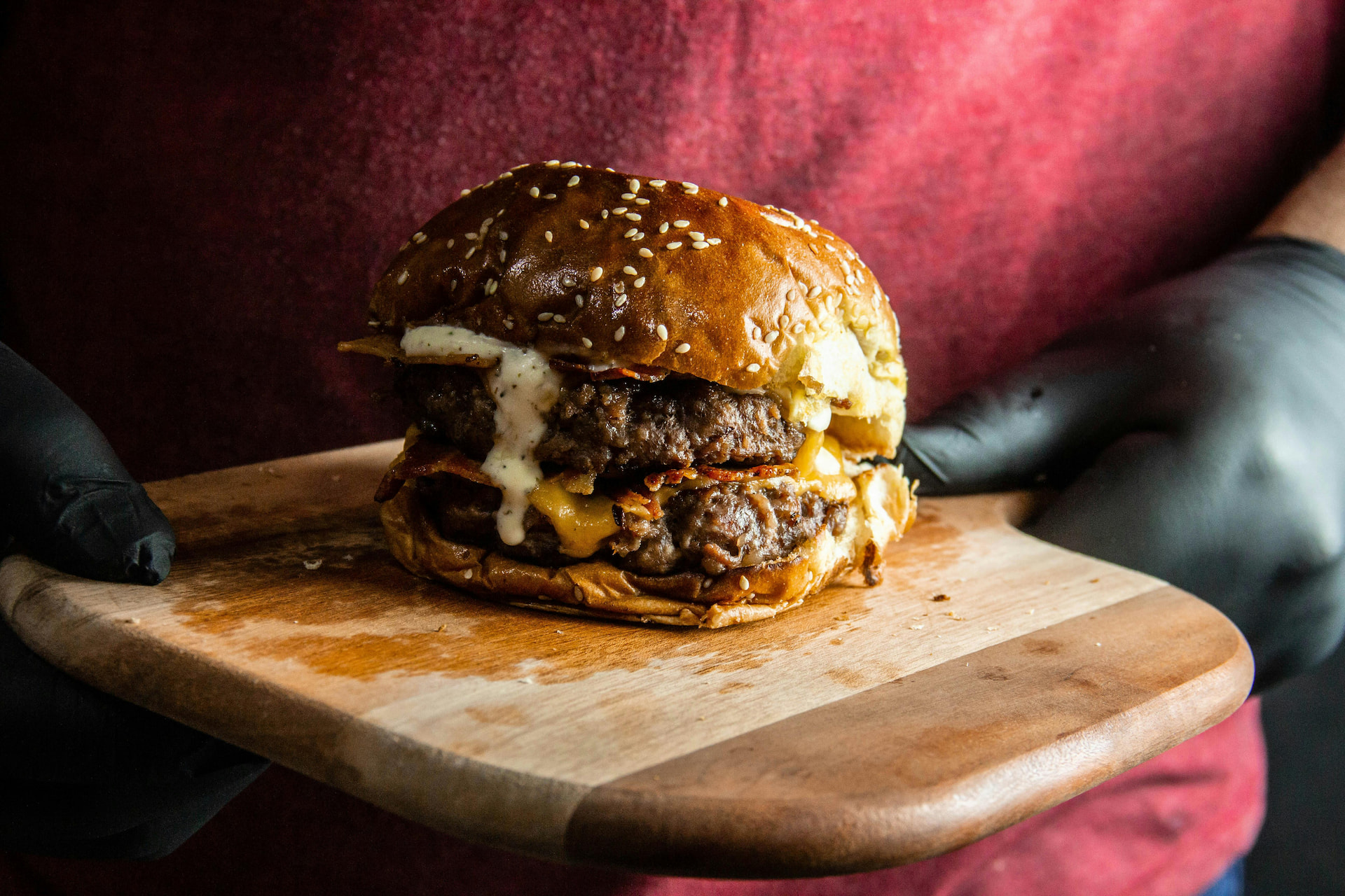 A smash burger being served by a waiter.