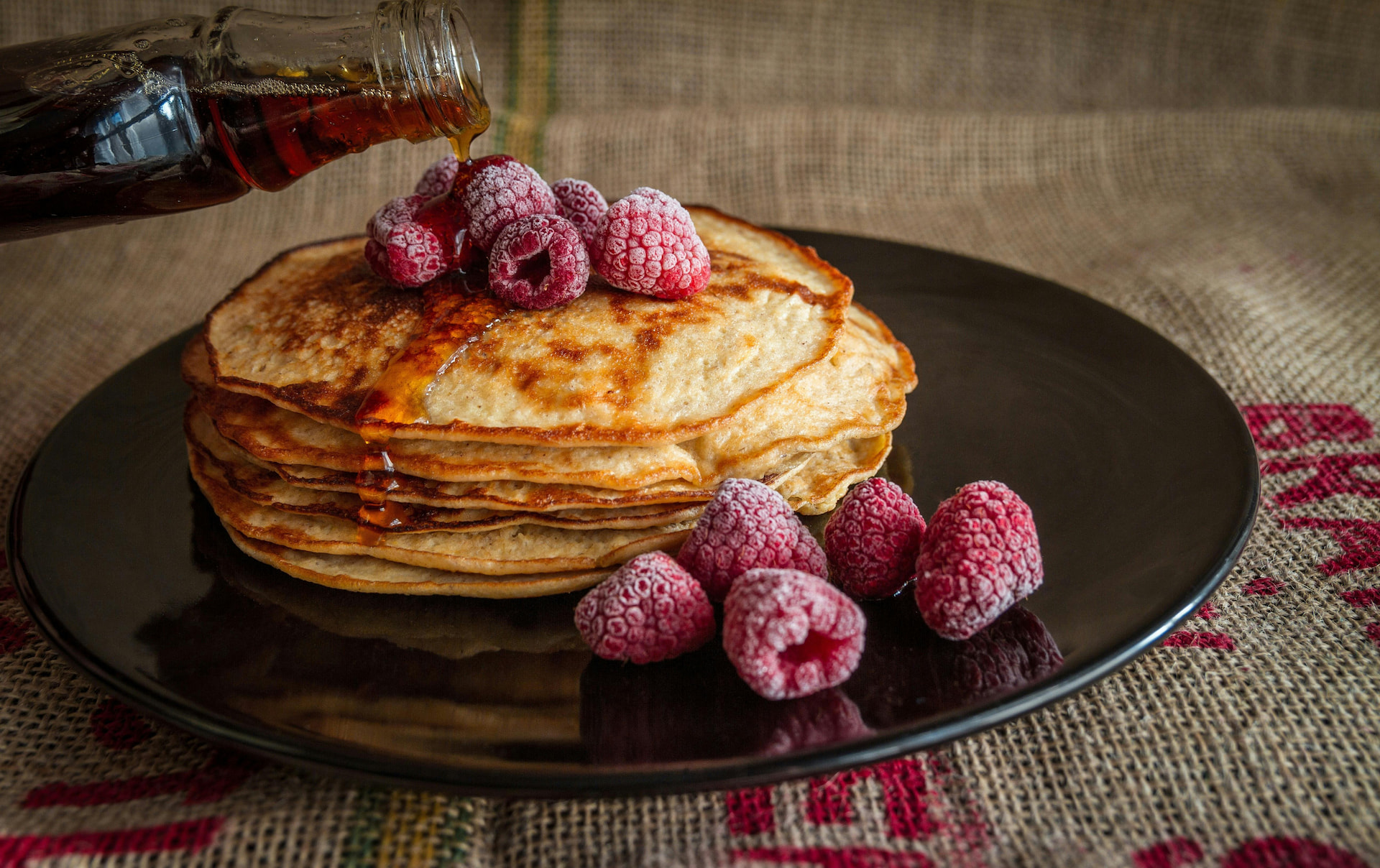 A photo of pancakes with berries besides it.