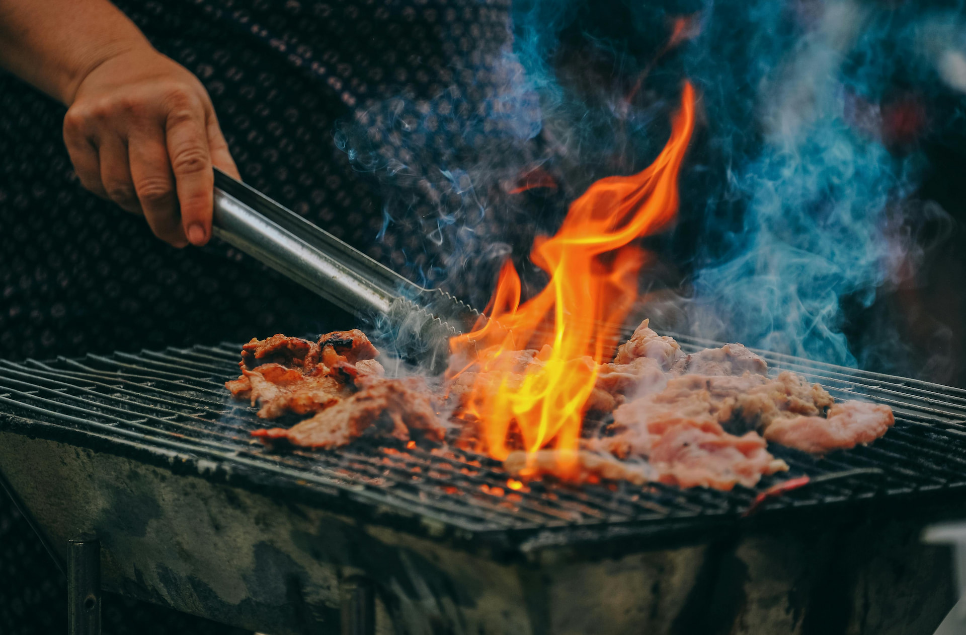 A man grilling meat on a grill