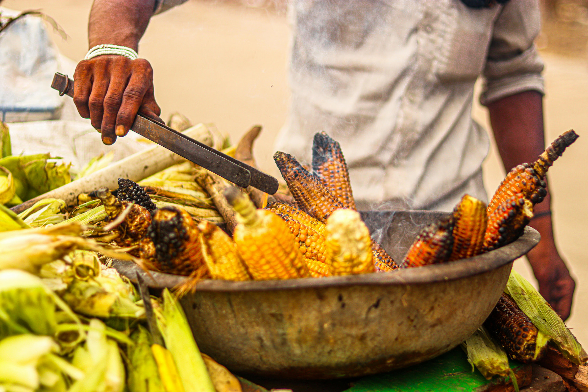 A person grilling corn